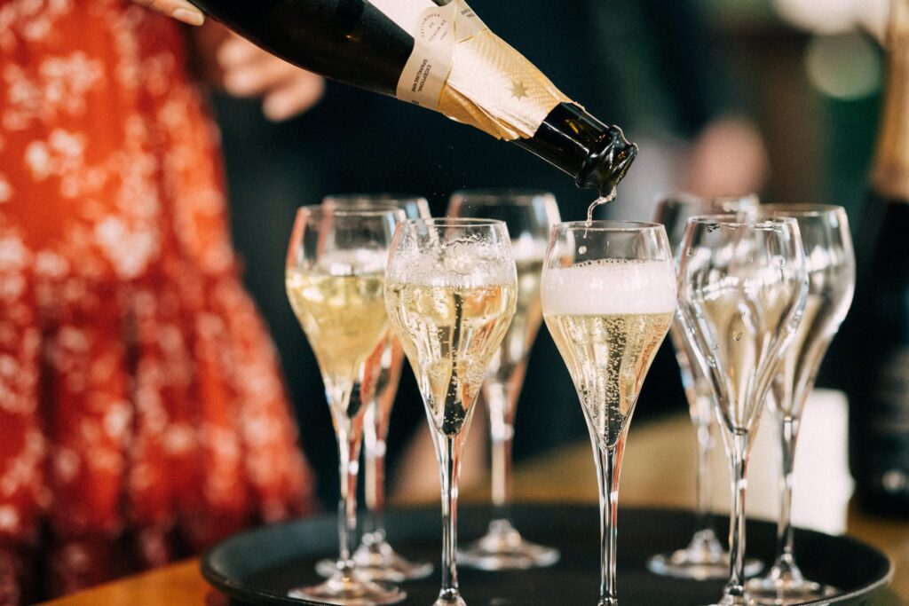 A tray of glasses being filled with champagne